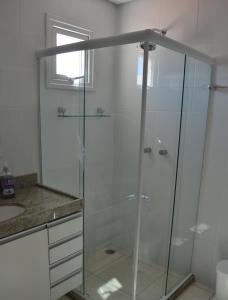 een glazen douche in een badkamer met een wastafel bij Flat Praia dos Carneiros in Praia dos Carneiros