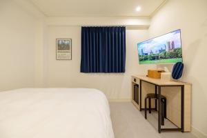 a bedroom with a bed and a tv on a wall at 미니호텔 먹 in Seoul