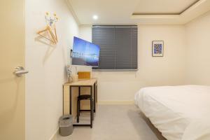 a bedroom with a bed and a table with a television at 미니호텔 먹 in Seoul