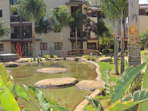 a garden with a pond in front of a building at Life Resort in Brasília