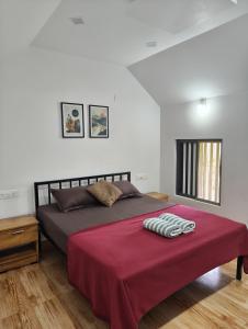 a bedroom with a large bed with a red blanket at Aadhya Homestay 4BHK in Wayanad