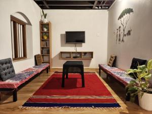 a living room with couches and a table on a red rug at Aadhya Homestay 4BHK in Wayanad