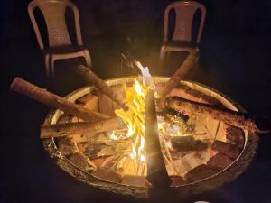 a fire pit with logs and a candle in it at DPD Beach Hotel in Pondicherry