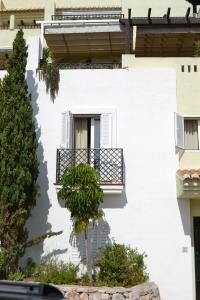 a white building with a balcony and a tree at Casa José in La Herradura