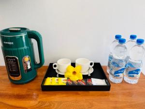 a tray with two cups and two bottles of water at For Rest Inn in Phumĭ Réach Born (2) +9 photos