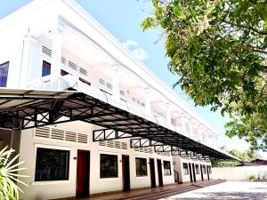 a white building with a balcony on top of it at For Rest Inn in Phumĭ Réach Born (2)