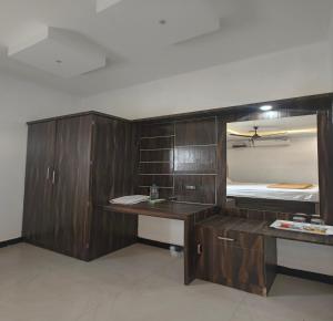 a bathroom with wooden cabinets and a sink and a bed at The Canalway Inn in Pollāchi