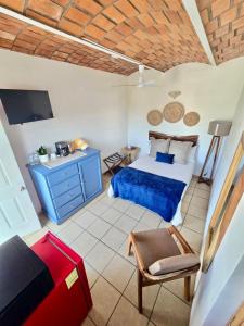 a bedroom with a bed and a tv and a chair at Tayau Bungalows B6 in Lo de Marcos