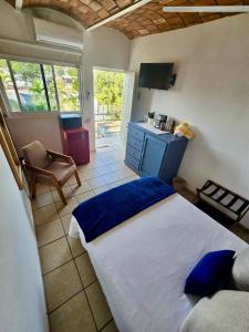 a bedroom with a bed and a kitchen with a table at Tayau Bungalows B6 in Lo de Marcos