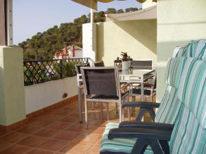 a balcony with chairs and a table with a television at Casa José in La Herradura