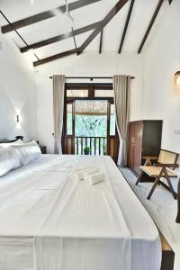 a large white bedroom with a large white bed at Mansion view - Rose Patals in Unawatuna