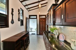 a kitchen with wooden cabinets and a counter top at Mansion view - Rose Patals in Unawatuna +29 photos