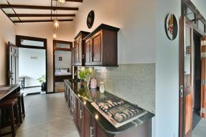 a kitchen with a stove and a counter top at Mansion view - Rose Patals in Unawatuna