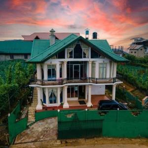 a house with a green roof and a car in front at Hill Paradise Nuwaraeliya in Nuwara Eliya