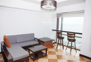a living room with a couch and a table and chairs at Eton Baypark Manila Bay in Manila +10 photos