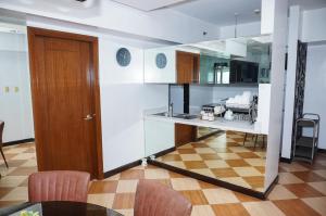 a kitchen with a table and chairs and a wooden door at Eton Baypark Manila Bay in Manila
