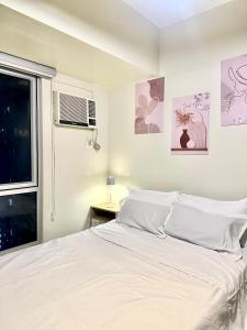 a white bedroom with a bed and a window at Riala Suite Cebu in Sampong +27 photos