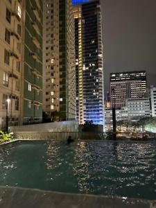 a swimming pool in the middle of a city at night at Riala Suite Cebu in Sampong