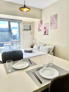 a room with a bed and a table with plates on it at Riala Suite Cebu in Sampong