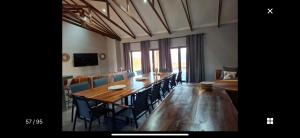 a dining room with a long table and chairs at Nectar Game Lodge in Buffelspoort