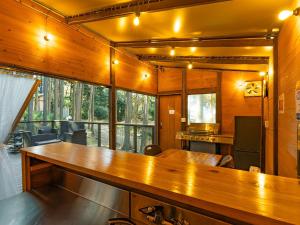 a kitchen with a long wooden table in a room at エメラルドの森 in Izunokuni