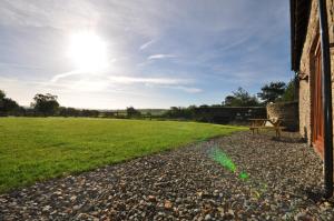 a bench sitting outside of a building next to a field at Montgomery Barn in Bideford