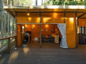 a wooden cabin with a deck with a table and chairs at エメラルドの森 in Izunokuni