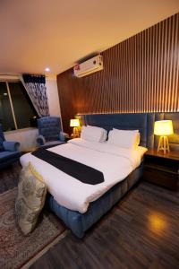 a hotel room with a large bed and a chair at Sardar Villa NathiGalli in Bāzār
