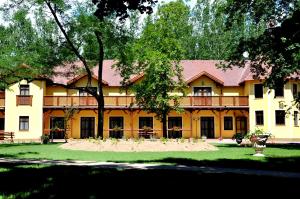 un gran edificio amarillo con un gran patio en Forster Vadászkastély és Szálloda, en Bugyi