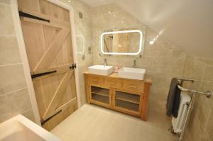 a bathroom with a sink and a mirror at Montgomery Barn in Bideford