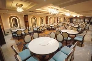 a banquet hall with tables and chairs and chandeliers at Hotel Northern Heights in Amritsar