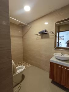 a bathroom with a toilet and a sink and a mirror at Ariani Villa in Jimbaran +5 photos