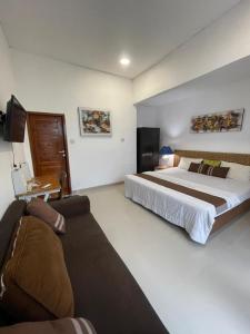 a bedroom with a large bed and a couch at Ariani Villa in Jimbaran