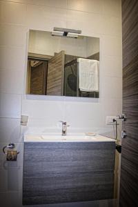 W łazience znajduje się umywalka i lustro. w obiekcie B&B ViaBrin 32 w mieście Altamura