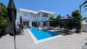 a house with a swimming pool with umbrellas at anemelie in Sotira