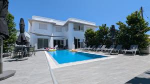 a villa with a swimming pool in front of a house at anemelie in Sotira