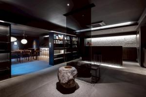 a living room with a table and a rock on the floor at Experience Ise Miyamachi Hotel in Ise