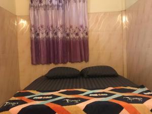 a bedroom with a bed and a window with curtains at The Panda Backpacker Hostel in Kampot