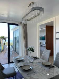 a dining room with a table and a chandelier at The Blue Lion Villa Samui in Chaweng Noi Beach