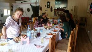 a group of people sitting at a table eating food at Casa de Vacanta Neagu in Gura Teghii