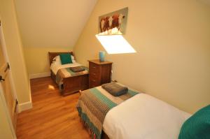 a small bedroom with two beds and a lamp at Montgomery Barn in Bideford