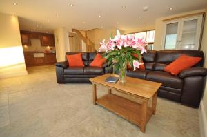 a living room with a couch and a table with pink flowers at Montgomery Barn in Bideford