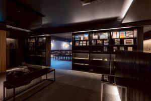 a room with a display case with a couch and tables at Experience Ise Miyamachi Hotel in Ise
