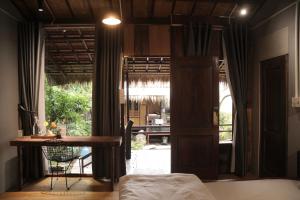 a bedroom with a table and a view of a patio at Cat Bungalow Stay in Cư Chinh