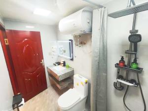 a bathroom with a white toilet and a red door at Snow Valley Ma Hua Inn in Wuchang +137 photos
