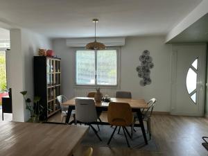 a dining room with a wooden table and chairs at Appartement spacieux in Jurançon