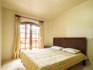 a bedroom with a large bed with a window at Cobertura Morro do Elefante in Campos do Jordão
