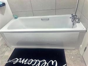 a white bath tub with a faucet and a rug at Precious Home in Monasterevin