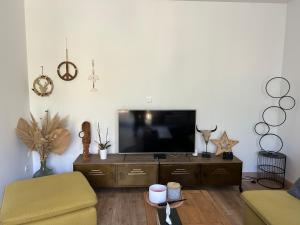 a living room with a flat screen tv and a couch at Appartement spacieux in Jurançon