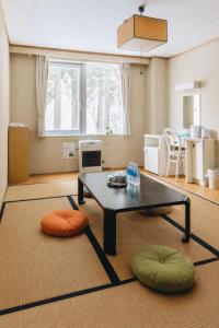 a living room with a coffee table and ottoman at 雪场缆车站旁 Hotel Justice-Ski IN Ski OUT-独立卫浴 in Seki